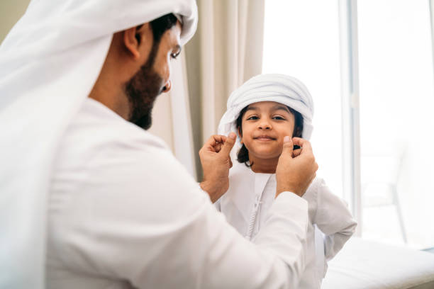 istock Arab man fixing keffiyeh to his son 1161386337