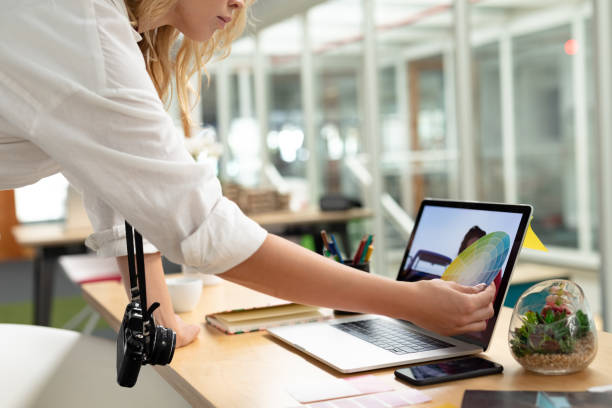istock Female graphic designer looking at color swatch in office 1161386725