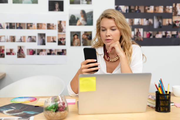 istock Female graphic designer using mobile phone at desk 1161387882