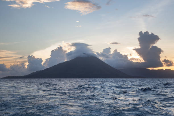 nuvens cobrem o vulcão no mar de banda - anel de fogo do pacifico - fotografias e filmes do acervo