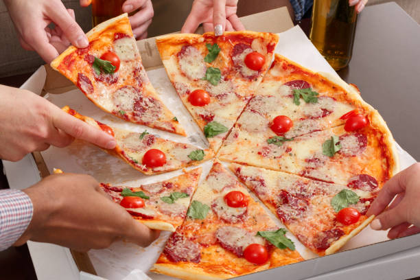 istock Friends taking slices of pizza from cardboard box 1161390723