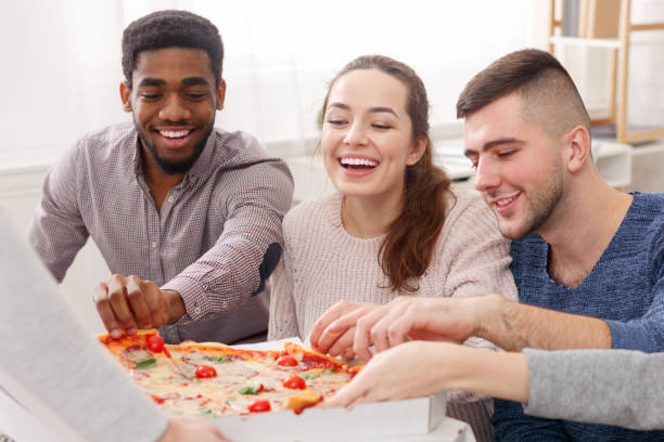 istock Happy friends eating pizza, having home party 1161390736