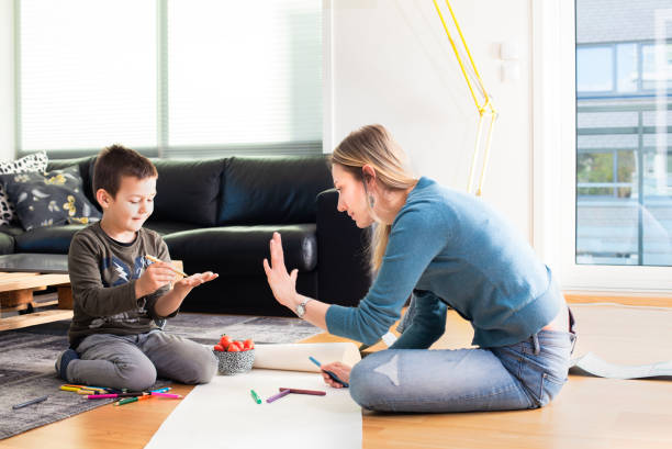 istock Mother and son plays at home with paintings 1161391147