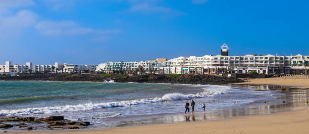 Family on Playa de Las Cucharas, the main urban beach of Costa Teguise, located on the east coast of the island of Lanzarote.