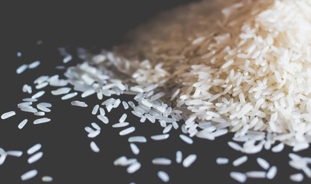 istock Close up white rice on black wood 1161404047