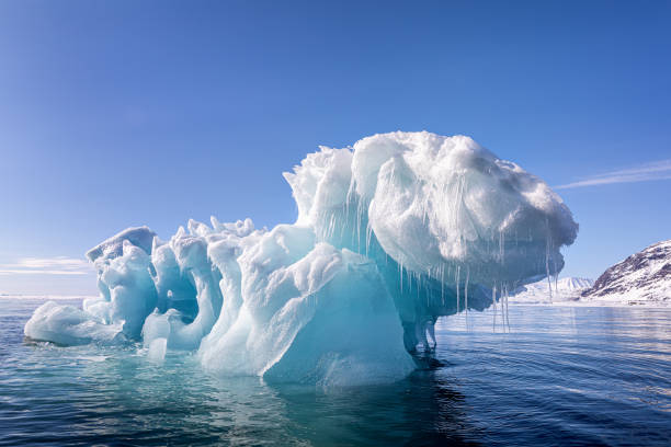 iceberg bleu de glace flottant dans les eaux arctiques du svalbard - cold frozen sea landscape photos et images de collection