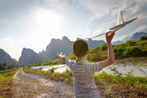 istock Asian boy playing with model plane outdoors 1161404914