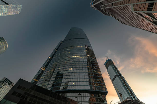 istock bottom-up view of rotating skyscrapers and flying clouds 1161408185