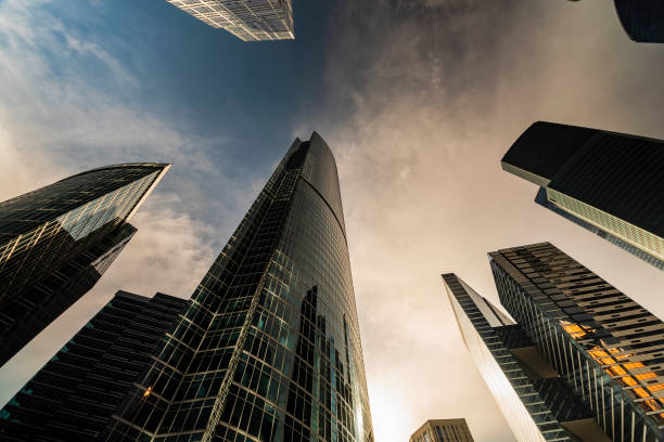 istock bottom-up view of rotating skyscrapers and flying clouds 1161408188
