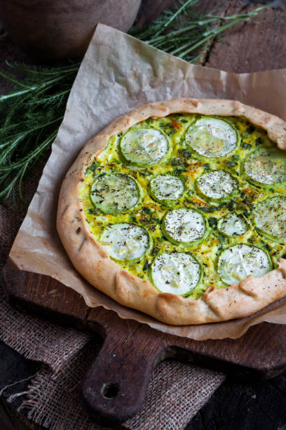 istock Homemade courgette and goat cheese pie on a dark rustic wooden board background 1161409178