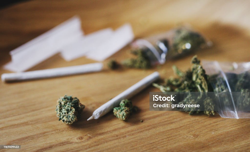 Made by man and mother nature Shot of dried marijuana and a rolled joint Cannabis Plant Stock Photo