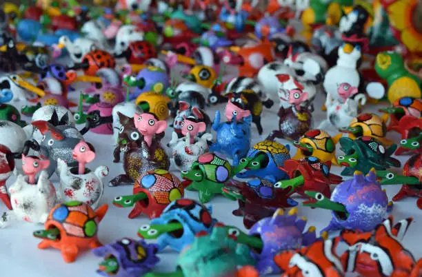 Cheerful and colorful bobblehead toys arranged in rows on a white background giving the overall effect of a jubilant parade.