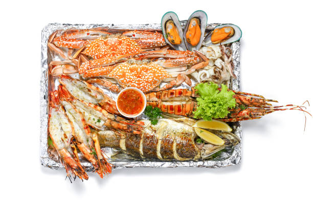 Roasted Mixed Seafood Platter Set contain Lobster, Fish, Blue Clab, Big Prawns, Mussels Clams and Calamari Squids with pieces of lemon & vegetables, Isolated on white background with Shadow, Top view. Roasted Mixed Seafood Platter Set contain Lobster, Fish, Blue Clab, Big Prawns, Mussels Clams and Calamari Squids with pieces of lemon & vegetables, Isolated on white background with Shadow, Top view. scorpionfish photos stock pictures, royalty-free photos & images