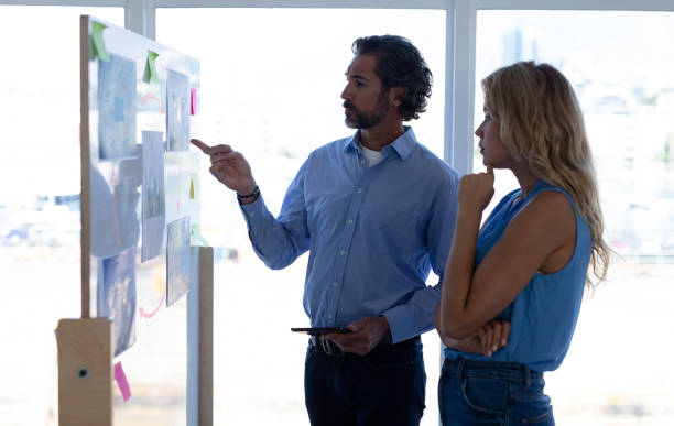 istock Business people discussing over graph on glass wall in a modern office 1161409856