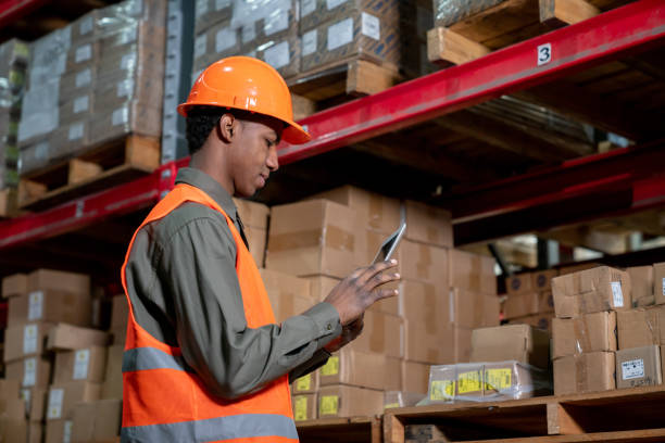 istock Black man working at a warehouse looking at the inventory on tablet 1161410937
