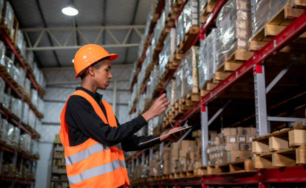 istock Young man preparing a shipping at a distribution warehouse looking at documents on clipboard 1161410956