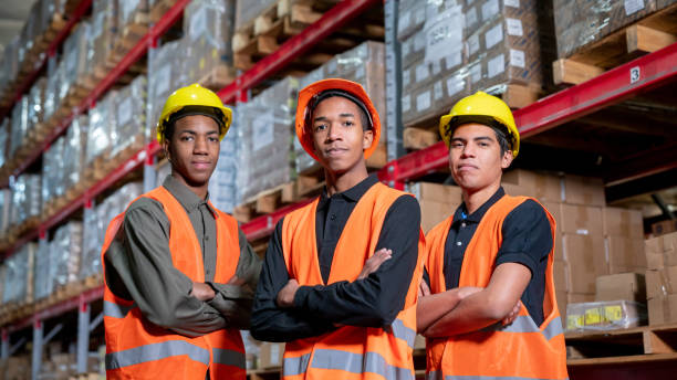 istock Confident team of manual workers at a distribution warehouse all facing camera with arms crossed 1161410957