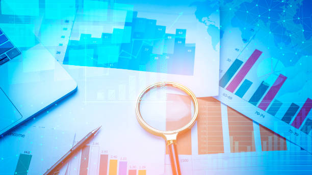 istock Magnifying glass and documents with analytics data lying on table, business finance background 1161412296