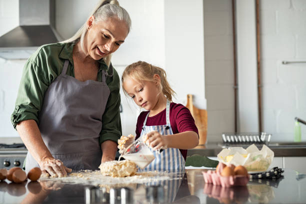 istock Little cute girl adding milk in dough 1161412439