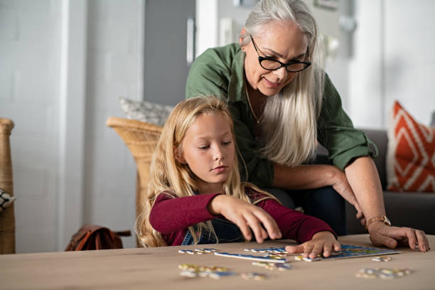 istock Girl doing jigsaw puzzle with grandmother 1161412447