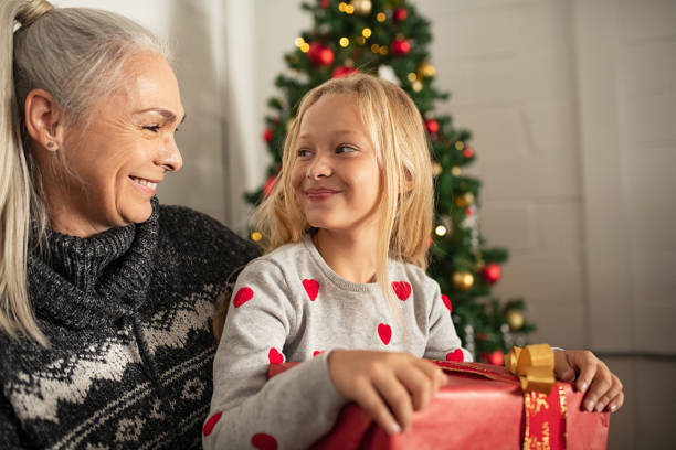 szczęśliwa dziewczyna trzymająca prezent świąteczny - grandmother giving gift child zdjęcia i obrazy z banku zdjęć