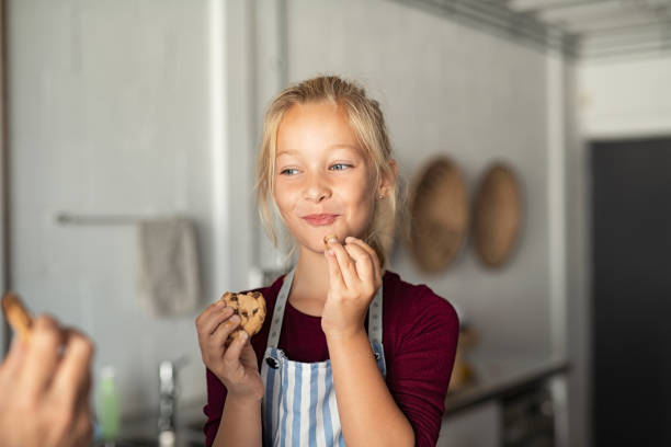 Funny cute girl eating chocolate cookie