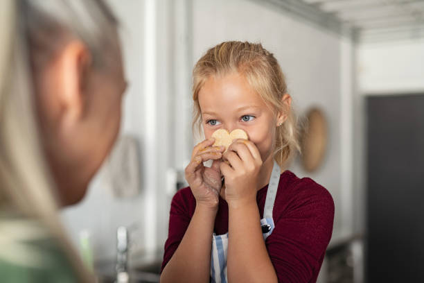 istock Girl holding cookie with funny face 1161413526