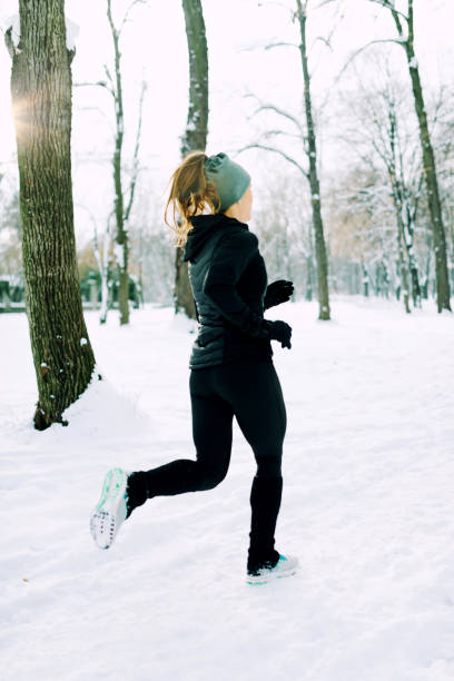 istock Female athlete jogging in park in winter 1161416413