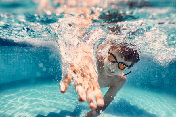 istock Little boy swimming crawl in pool 1161416585