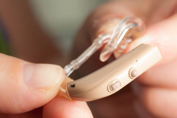 istock senior person holding hearing aid closeup 1161419232