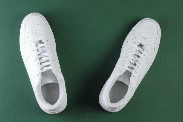 istock White hipster sneakers on a green background. Top view 1161419849