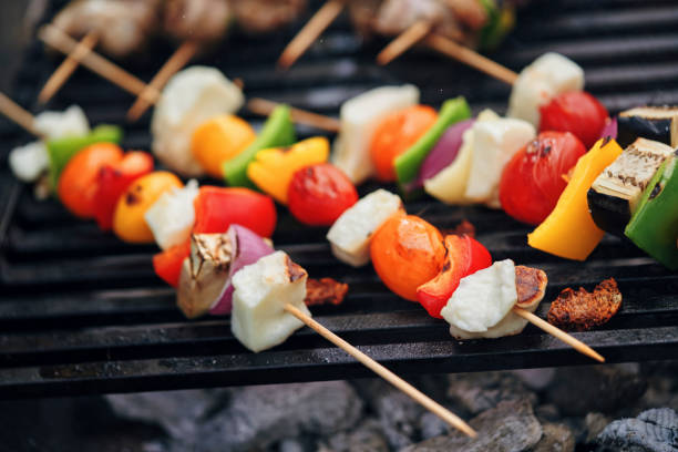 Young Family Preparing Vegetarian Kebab with Grilled Cheese and Vegetables Outside