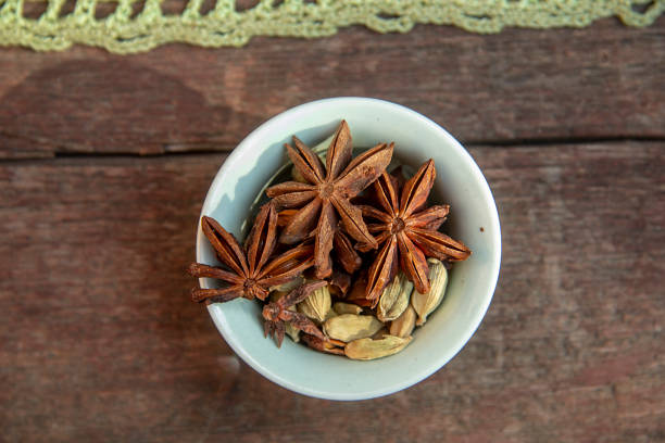 star anise and cardamom in a green bowl.