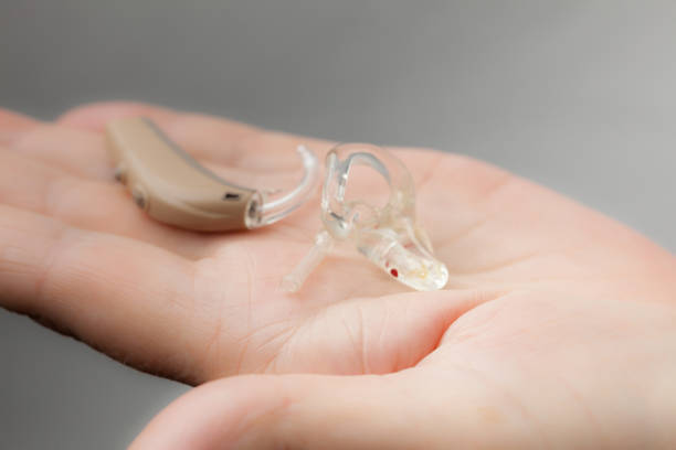 istock senior person holding hearing aid closeup 1161421387