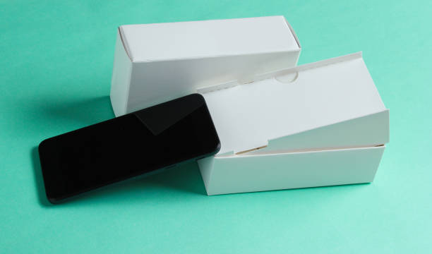 istock New smartphone with box on blue background. Minimalism concept, unboxing 1161421448