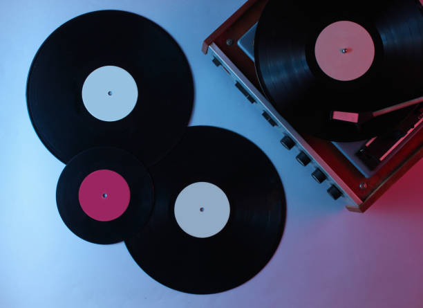 istock Retro vinyl record player. Vinyl records. Neon light, top view 1161421459