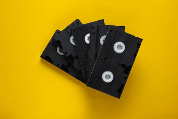 istock Stack of retro video cassettes on yellow background. Top view 1161421461