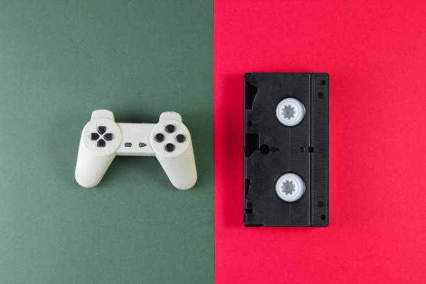 istock Retro gamepad, video cassette on red-green background. Top view. 1161421819