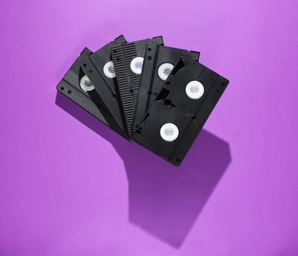 istock Stack of retro video cassettes on purple background. Top view 1161421891