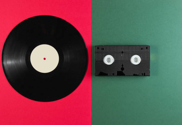 istock Vinyl record and video cassette on a green-red background. Retro style. Top view. 1161421899