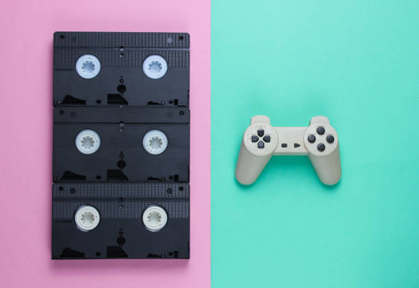 istock Gamepad and  retro video cassettes. Minimalism studio shot on pastel background. Top view 1161421909