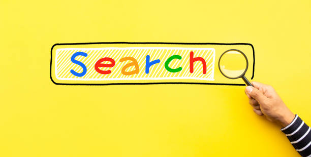 黄色のスペースの背景に検索テキストアイコンを持つ虫眼鏡を使用して男性の手で概念を検索 - magnifying glass book scrutiny research ストックフォトと画像