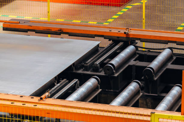 istock Steel sheet moving on roller conveyor, close up 1161424099