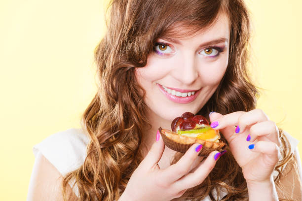 istock Smiling cute woman holds fruit cake in hand 1161427901