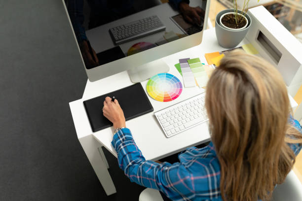 istock Female graphic designer using graphic tablet at desk 1161427910