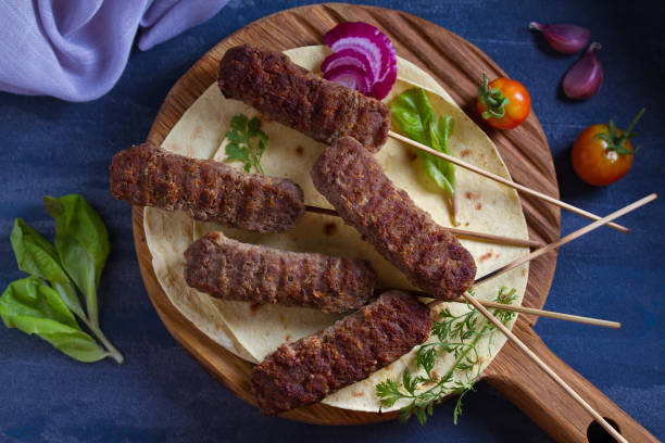 istock Kofta kebabs on skewers with pita bread,  vegetables and yogurt sauce 1161428100