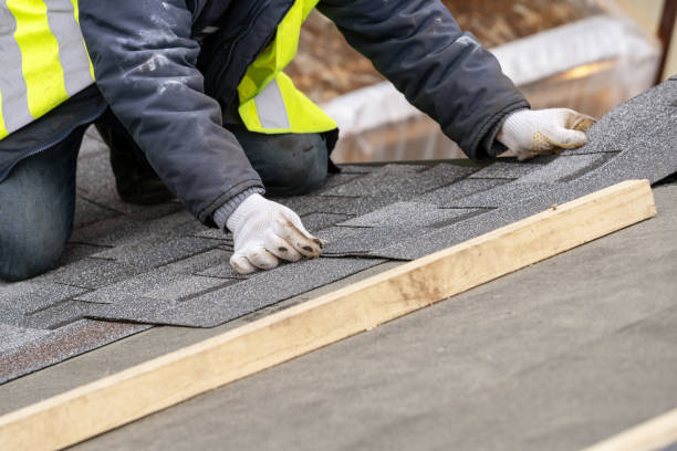 istock Mature and skilled workman in uniform work wear installing asphalt or bitumen tile on top of the roof under construction house 1161429623