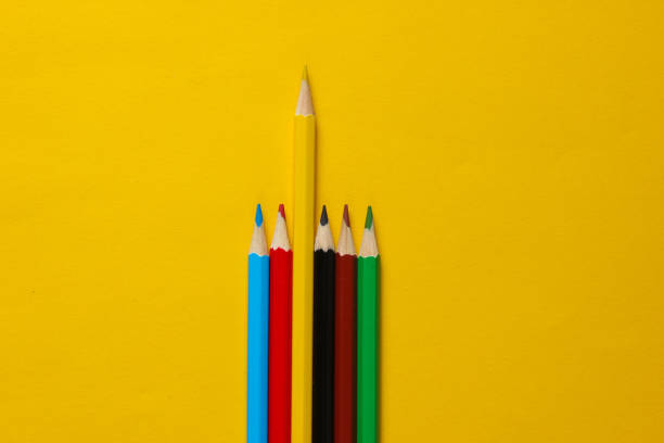 istock Set of colored pencils on yellow background. Uniqueness concept.  Top view 1161429625