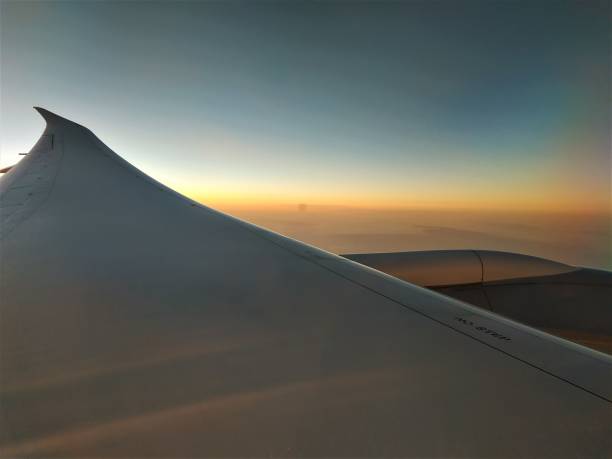 istock View out of plane window over wing into sunset 1161431052