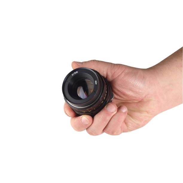 istock old lens on a hand and white background 1161431166